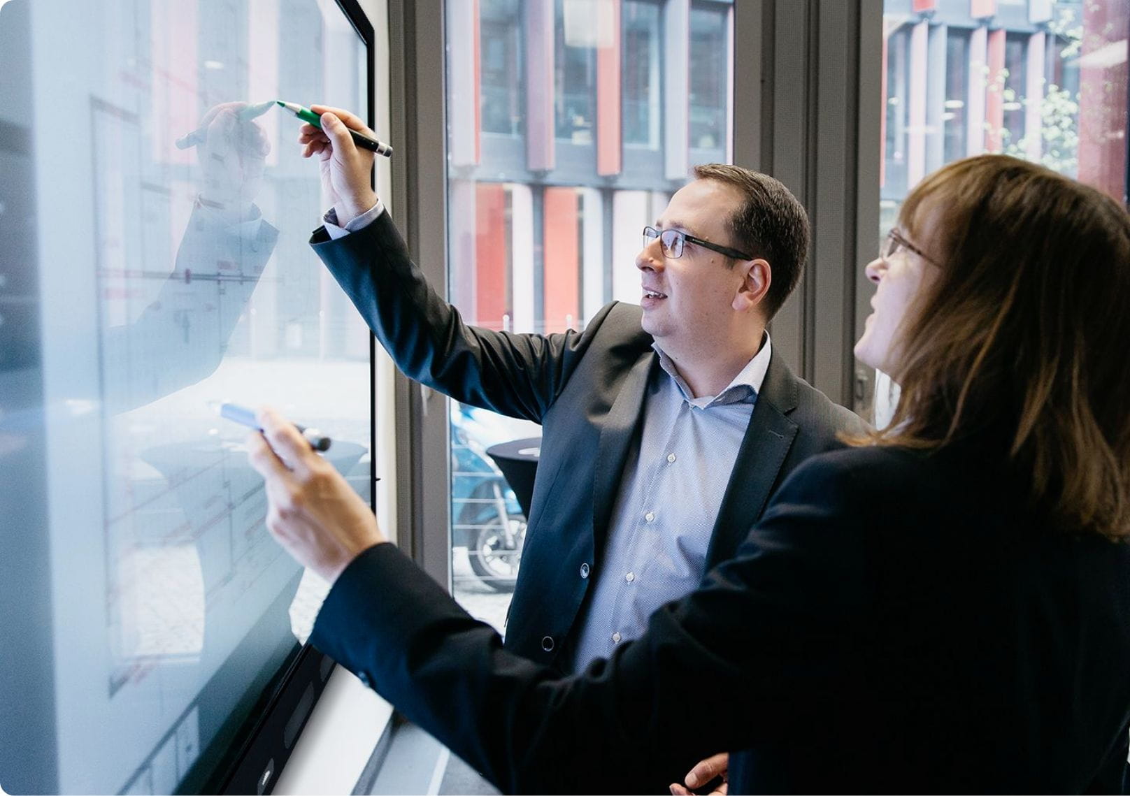 Business professionals engaging with a SMART Board, highlighting the HyPr Touch™ with InGlass technology for precise, multi-touch interaction.