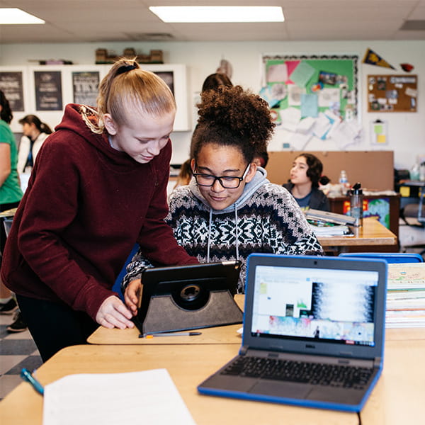 Two students working collaboratively on a tablet