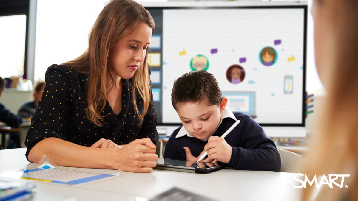 A special education teacher working one-on-one with a student on a tablet.