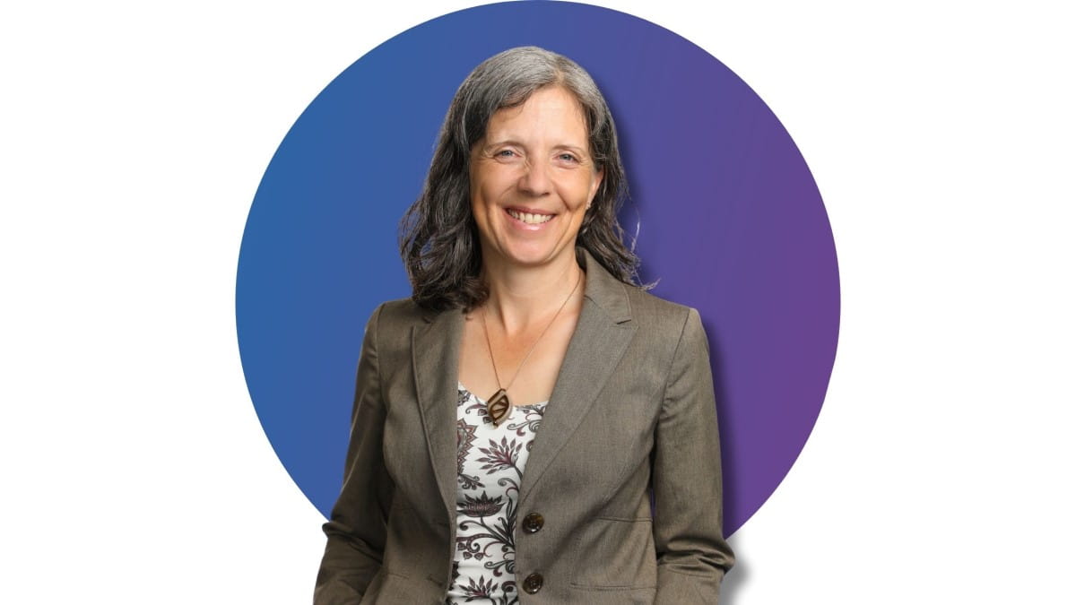 Kris Astle, smiling confidently, dressed in a business suit against a gradient blue to purple circular background.