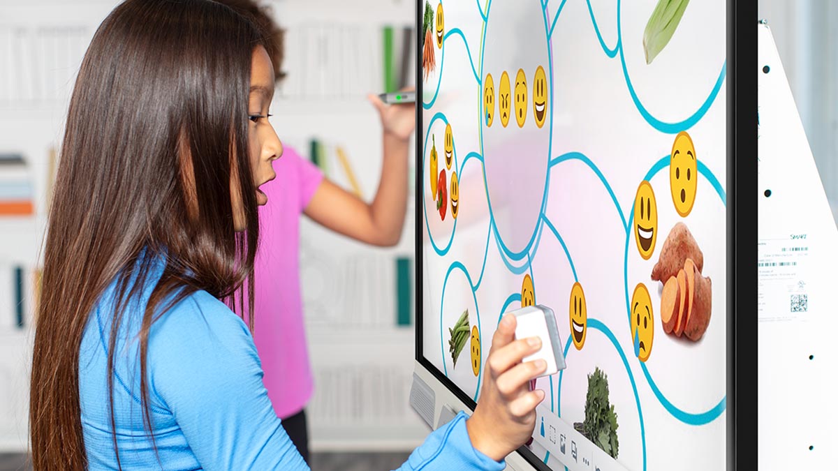 Students engage with a SMART Board in the classroom, using digital stamps to complete an educational activity on food groups.