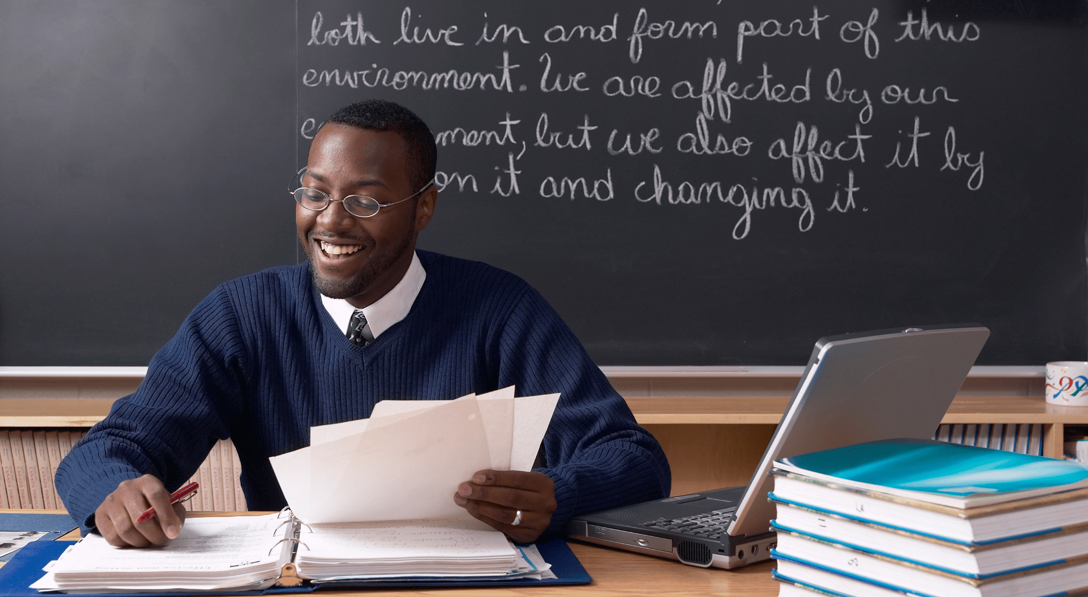 A happy teacher reviewing student work.