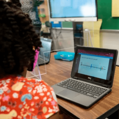 student with student device listening to teacher