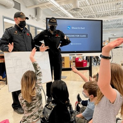 Students listening to navy sailors in class