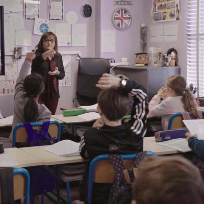 Teacher at West Point School in France, calling on a student to answer a question in a classroom.